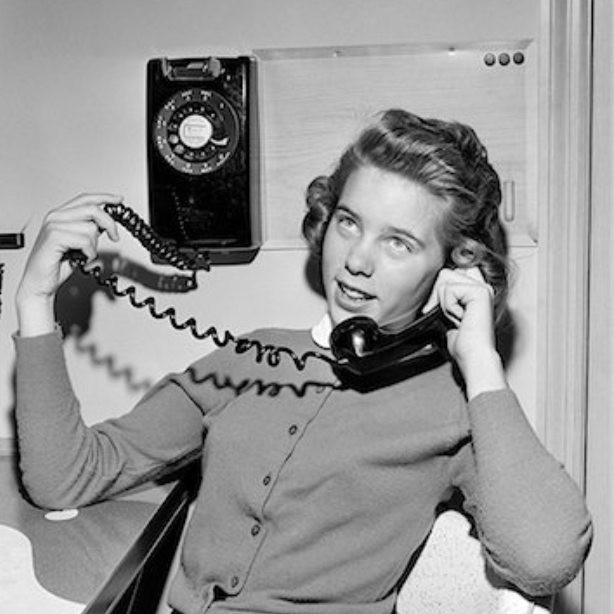 woman on a traditional phone, in black and white